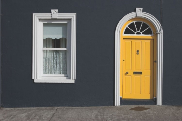 Uma fachada de casa com uma porta amarela