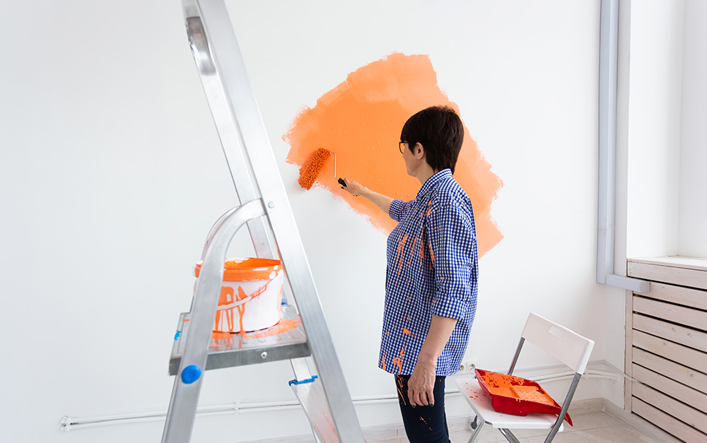 Mulher pintando a casa